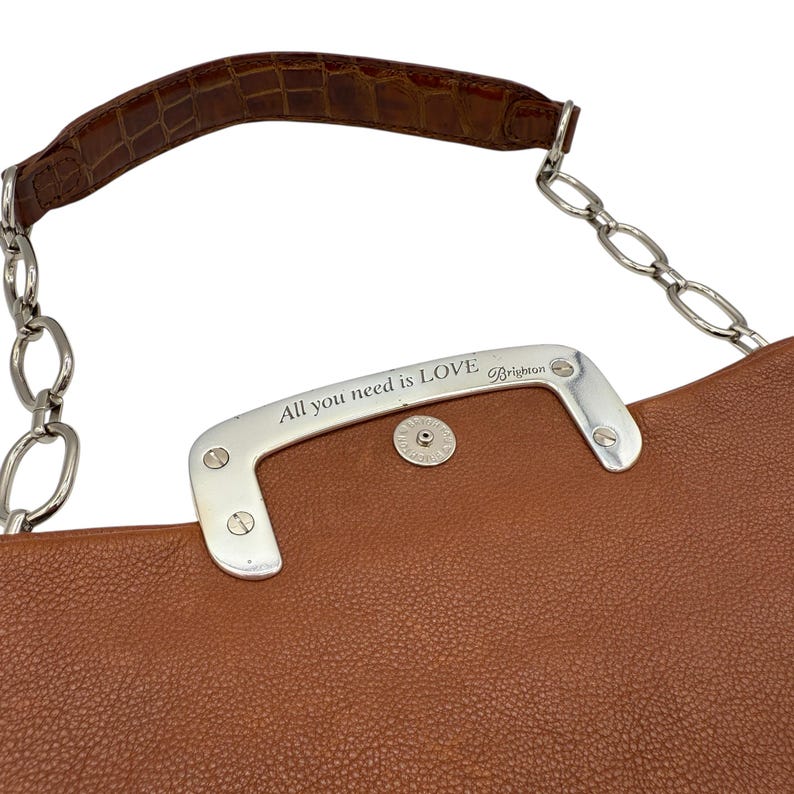 Puede incluir: Bolso de mano de cuero marr&oacute;n con un asa plateada que dice "All you need is LOVE" y un asa marr&oacute;n con textura de cocodrilo. El bolso tiene una correa de cadena plateada.