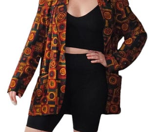 May include: A patterned blazer in shades of brown, red, and gold. The blazer features a geometric design and is paired with a black top and black biker shorts. The blazer has a classic, tailored fit.