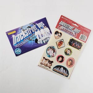 Pode incluir: Dois itens colecionáveis ​​dos Backstreet Boys: um pacote lacrado de 72 cartões colecionáveis ​​Millennium e uma folha de adesivos com os membros da banda. A folha de adesivos inclui várias imagens e o logotipo da banda.