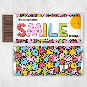 May include: A chocolate bar with a wrapper featuring a colorful design of smiley faces. The wrapper has the words "Make someone SMILE today" with a smiling sun illustration. The bar itself is visible on the left side.