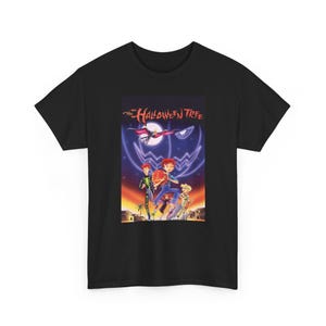 Op de afbeelding: Een zwart t-shirt met korte mouwen en een grafische print van de filmposter The Halloween Tree. Het ontwerp toont vier kinderen in kostuums, een grote gloeiende maan, een donkere lucht en de paarse omtrek van een pompoengezicht.