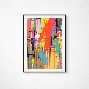 Puede incluir: Impresión artística abstracta en un marco negro. La obra presenta una vibrante mezcla de colores, incluyendo naranja, amarillo, turquesa y morado, con salpicaduras y pinceladas. El fondo tiene una textura de vetas de madera.