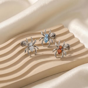 May include: A set of three ceramic mugs with a speckled, matte finish. The mugs are in shades of cream, light gray, and dark gray. Each mug has a simple, minimalist design, perfect for coffee or tea.