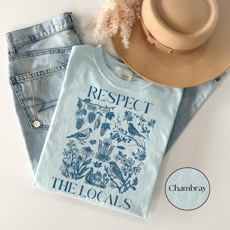 Vintage wildlife graphic T-shirt reading Respect The Locals with botanical forest illustration and birds, cozy nature lover Comfort Colors chambray shirt.