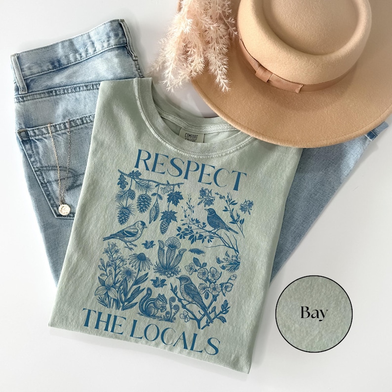 Vintage nature lover graphic T-shirt with “Respect The Locals” text and forest wildlife illustration including birds, plants, and woodland animals printed on Comfort Colors bay yellow tee.