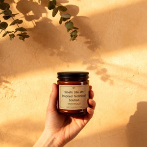 A hand holding the software engineer candle, showing a clear close-up of the witty coder joke on the label.