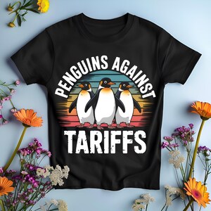 Könnte beinhalten: Schwarzes T-Shirt mit dem Text "Penguins Against Tariffs" und einer Grafik von drei Pinguinen. Das Design beinhaltet einen Sonnenuntergang mit orange, rot, blau und gelb. Das T-Shirt ist von Blumen umgeben.