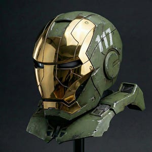 May include: A green and gold helmet, blending Iron Man and Halo styles. The helmet has a gold faceplate and details, with the number "117" in white. The design is intricate, likely a cosplay piece or collector's item, with a weathered finish.
