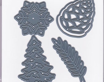 May include: A set of five metal die cut and embossing stencils. The stencils are in the shape of a snowflake, pine cone, tree, and two fern leaves. The stencils are silver in colour and are packaged on a white card with the text "Darice Die Cut & Embossing Stencil" and "5PC".