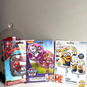 Op de afbeelding: Drie folie ballonpakketten met populaire cartoonfiguren. Het eerste pakket heeft Spiderman, het tweede heeft Paw Patrol-karakters en het derde heeft een Minion van Despicable Me.