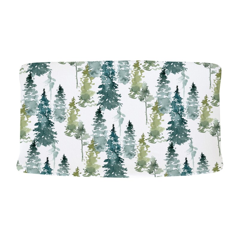 May include: A white fabric with a watercolor pattern of green and blue pine trees. The fabric has a subtle texture.