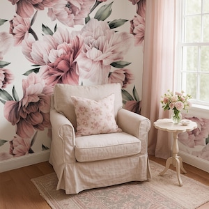 May include: A living room with a floral peony wallpaper in shades of pink. A beige armchair with a floral cushion sits on a patterned rug. A small side table holds a vase of roses, creating a soft, inviting atmosphere.