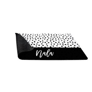 May include: Black and white doormat with a black and white polka dot pattern and the name "Nala" written in white on a black background.