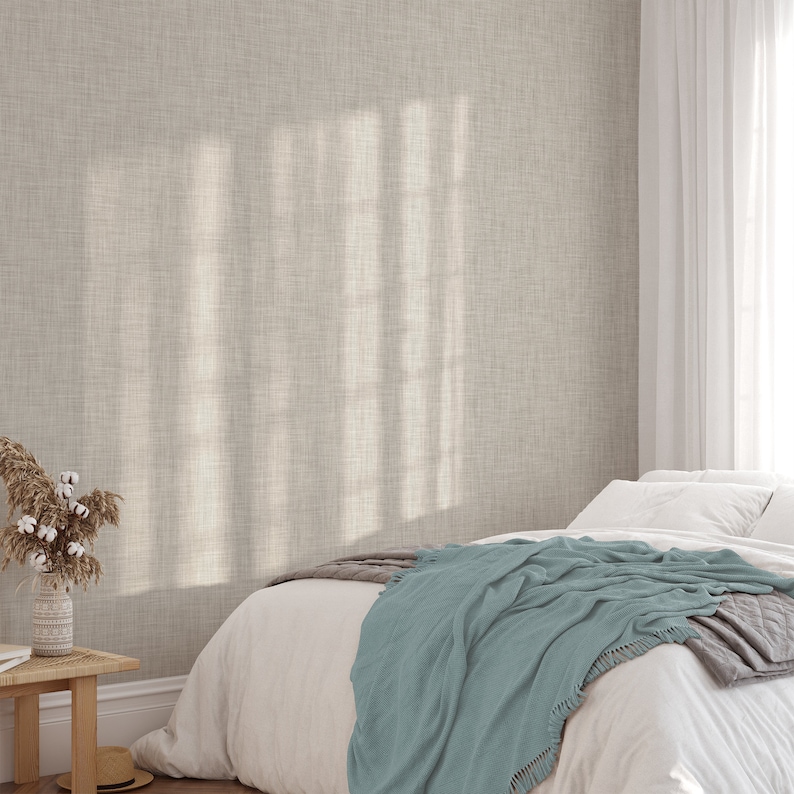 May include: A light beige textured wallpaper with a bed with white bedding and a teal throw blanket.
