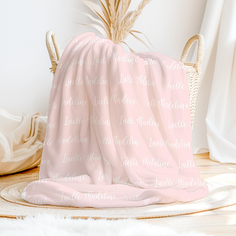 May include: A pink fleece blanket with the names "Luelle Madeline" repeated in white text.