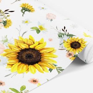 May include: A roll of white wallpaper featuring a watercolor floral pattern. The design includes large yellow sunflowers with dark brown centers, smaller white daisies, and soft peach-colored blossoms, all accented with green leaves and stems.
