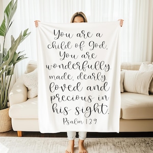May include: White throw blanket with black text that reads "You are a child of God, You are wonderfully made, dearly loved and precious in his sight. Psalm 139"