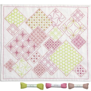 May include: White square textile with a geometric pattern of embroidered diamonds in shades of pink and green. The design includes various stitch patterns. Three spools of thread in matching colors are at the bottom.