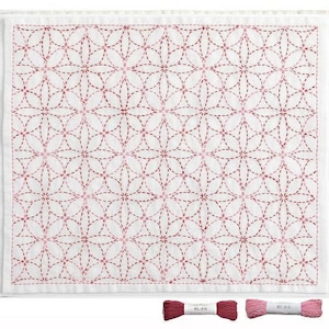 May include: White fabric with a repeating floral pattern embroidered in shades of red. The design features overlapping circles forming flower-like shapes. Two spools of red embroidery thread are at the bottom.