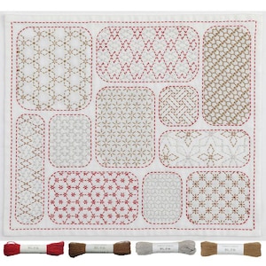 以下が含まれることがあります： 白地の正方形の布に、赤、茶色、金色の糸で様々な幾何学模様が刺繍されています。模様は角が丸い長方形の形の中にあります。様々な色の糸巻きがいくつか下にあります。