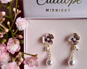 Enamel floral stud earrings with detachable dangling faux pearls. Whimsical pearlescent ivory with plum purple detailing.