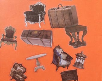 May include: A selection of stickers depicting miniature antique furniture. The stickers include ornate chairs, chests, a table, a side table, a dresser, and suitcases. The color scheme is mainly brown, with gold, white, and purple accents.