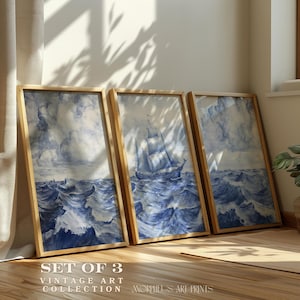 Puede incluir: Conjunto de tres láminas de arte vintage enmarcadas. Cada lámina presenta una pintura de acuarela azul y blanca de un velero en el mar. Las obras de arte se exhiben en marcos de madera. El texto "SET OF 3" y "VINTAGE ART COLLECTION" es visible.