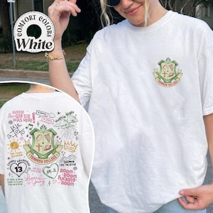 May include: White t-shirt with a green and red crest on the front that says "Tommen College". The back of the shirt has a variety of hand-drawn designs and text, including "Gussie Thor Gib Sie Was Here", "Too much Sunshine", "Johnny Kavanah 13", "This is a love story", "Am-Jl", "Shannon Like the River", "Boom Boom Fucking Boom", and "Hughie Biggs".