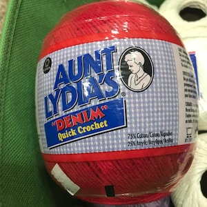 May include: A red ball of Aunt Lydia's "Denim" Quick Crochet yarn. The label says 75% cotton, 25% acrylic.
