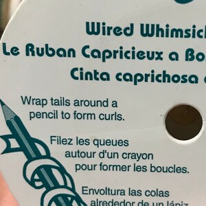 May include: A white spool of Wrights Wired Whimsical ribbon. The label includes instructions in English, French, and Spanish, with a pencil graphic. The text advises wrapping the ribbon around a pencil to form curls.