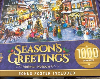 Könnte beinhalten: Ein 1000-teiliges Puzzle mit dem Titel "Season's Greetings", das eine viktorianische Urlaubsszene zeigt. Das Bild zeigt ein verschneites Dorf mit Menschen, Pferdekutschen und einem Weihnachtsbaum. Ein Bonus-Poster ist enthalten.