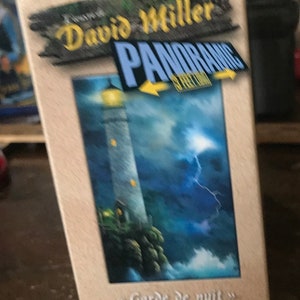 May include: A 500-piece jigsaw puzzle box featuring a painting of a lighthouse with a lightning bolt in the sky. The box is beige with a yellow puzzle piece in the top left corner. The title of the puzzle is "David Miller Panoramic" and the painting is titled "Garde de nuit". The box also features the Master Pieces logo.