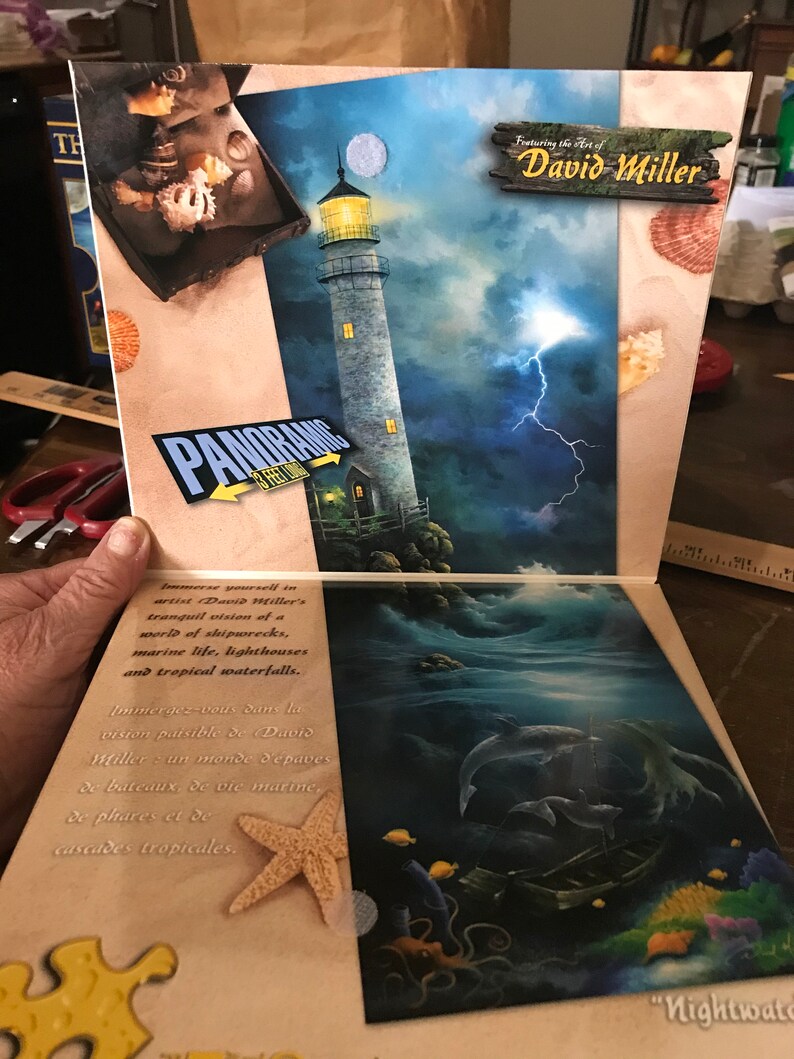 May include: A panoramic jigsaw puzzle featuring the art of David Miller. The puzzle depicts a lighthouse on a rocky shore with a stormy sky and lightning. The puzzle box also features a starfish and a piece of the puzzle.