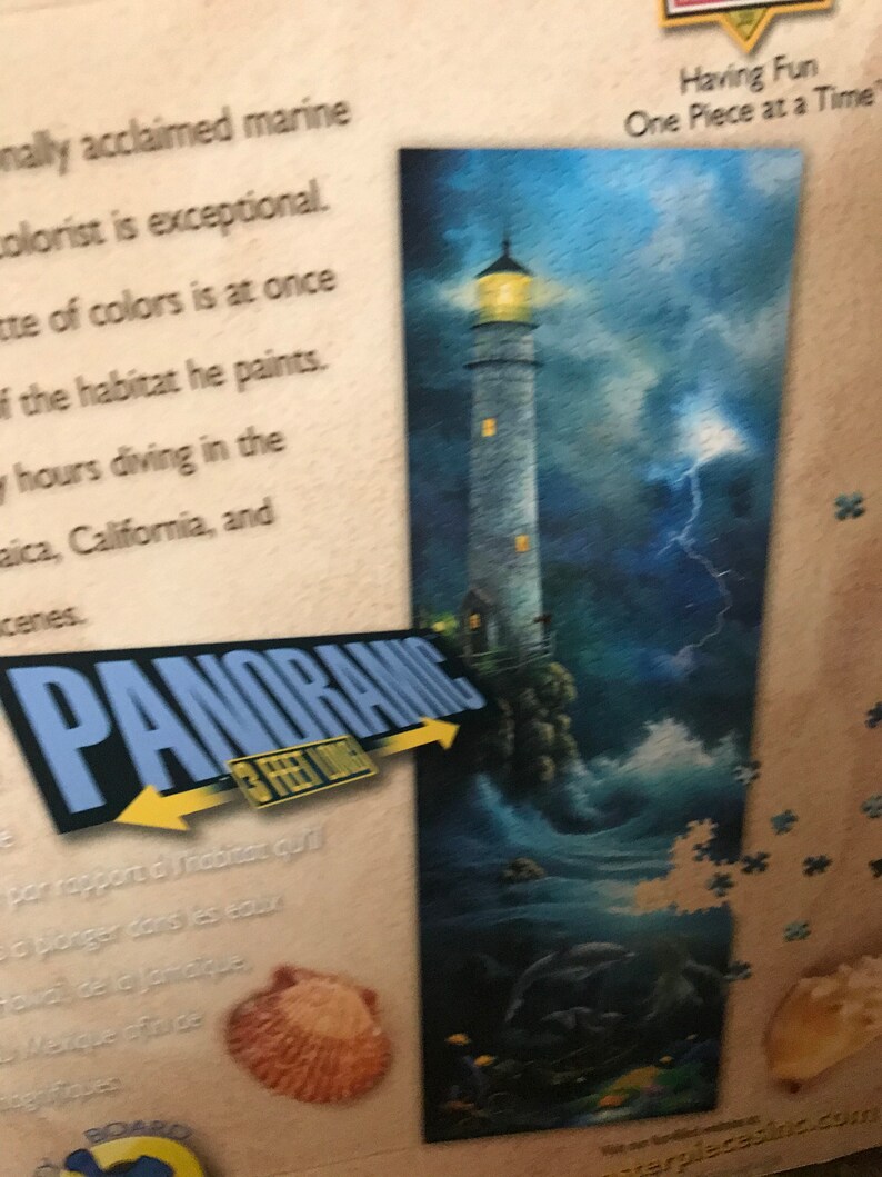 May include: A panoramic jigsaw puzzle featuring a lighthouse with a yellow light, a stormy sea, and the text "Having Fun One Piece at a Time".