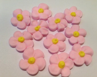 100 pink with yellow center royal icing flowers  Approx. size  1/2”