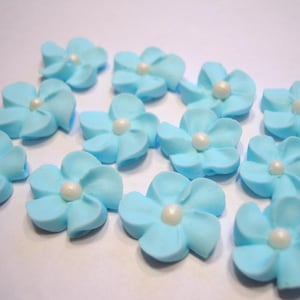 100 blue royal icing flowers Approx. size 3/4” with pearl sugar center