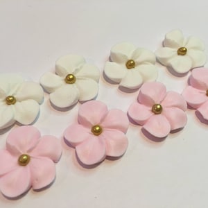 100 royal icing flowers ( 50 white and 50 pink) Approx. size 3/4” with gold sugar center