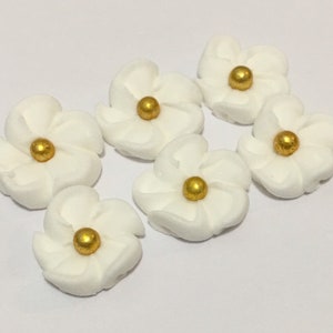 100 white royal icing flowers Approx.size 1/2” with gold sugar center