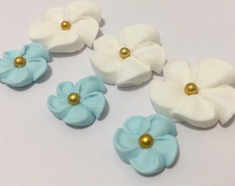 100 sugar flowers ( 50 white, 50 blue) approx. size 1/2” and 3/4” with sugar gold center