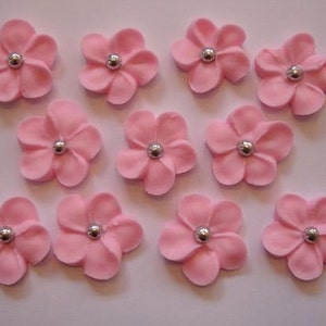 100 pink royal icing flowers Approx. size 3/4” with silver sugar center.