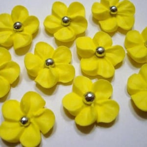 100 yellow royal icing flowers Approx. size 3/4” with silver sugar center