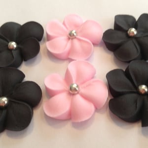 100 royal icing flowers ( 50 pink and 50 black) Approx. size 3/4” with sugar silver center