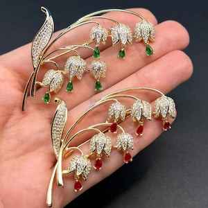 May include: A white ceramic mug with a black handle and the text "But First, Coffee" in a bold, black font. The mug is set against a blurred background, suggesting a cozy setting. The mug appears to be approximately 4 inches tall.