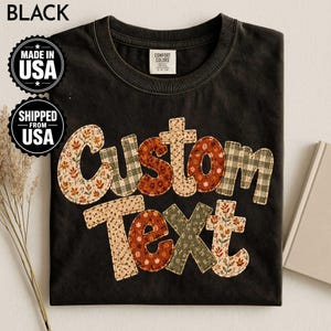 Può includere: Una t-shirt nera con le parole Custom Text in un carattere grande e squadrato. Ogni lettera è riempita con un motivo in tessuto diverso, inclusi motivi floreali in arancione, marrone e crema, oltre a motivi a quadri verdi e bianchi.