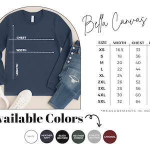May include: A navy blue long-sleeve shirt with size and color options. The shirt is displayed with a size chart showing measurements in inches. Available colours include white, heather navy, black heather, heather forest, athletic heather, and cardinal.