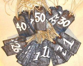 May include: A collection of rustic wooden tags with white numbers, each tag is tied with twine. The numbers range from 1 to 50.