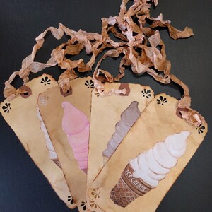 May include: Five brown paper tags with scalloped edges and a lace ribbon. Each tag features a different ice cream cone illustration. The text "ICE CREAM" is printed on one of the tags.