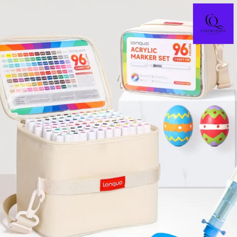 May include: A beige fabric carrying case with a set of 96 acrylic markers. The case is open, revealing the markers and a color chart. A second case is visible, along with two decorated Easter eggs. The brand name "Languo" is visible.
