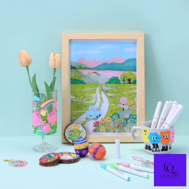 May include: A still-life arrangement featuring a framed landscape painting, a decorated glass, a mug with cartoon faces, and various decorative wooden rounds and painted eggs. Several colorful markers and a pair of tulips are also present.