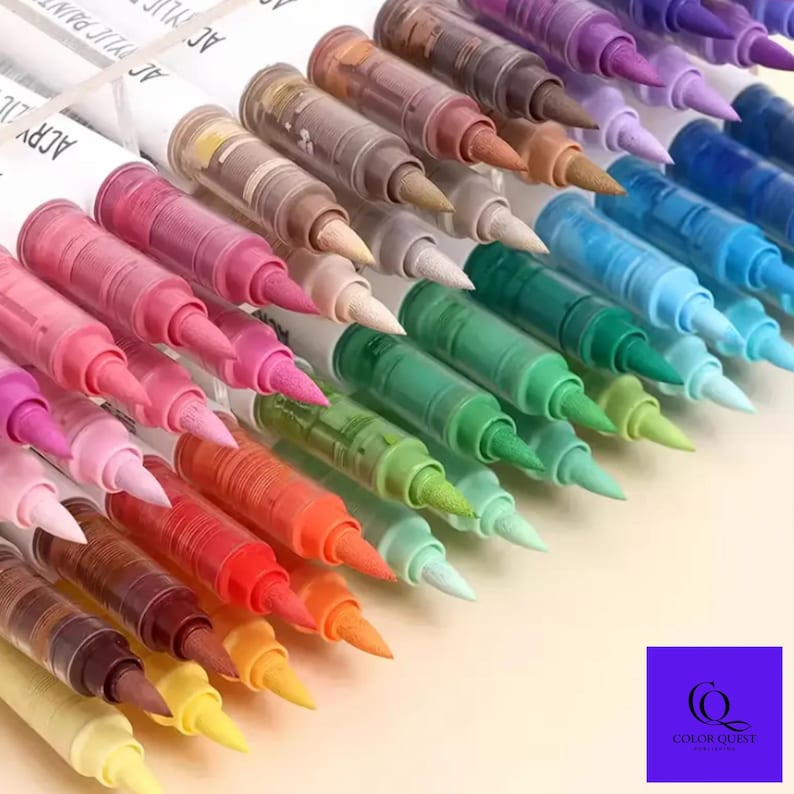 May include: A collection of acrylic paint pens in various colors, including pink, green, blue, and brown. The pens have white barrels with the words "ACRYLIC PAINT" printed on them. The tips are brush-style, and the pens are arranged at an angle.